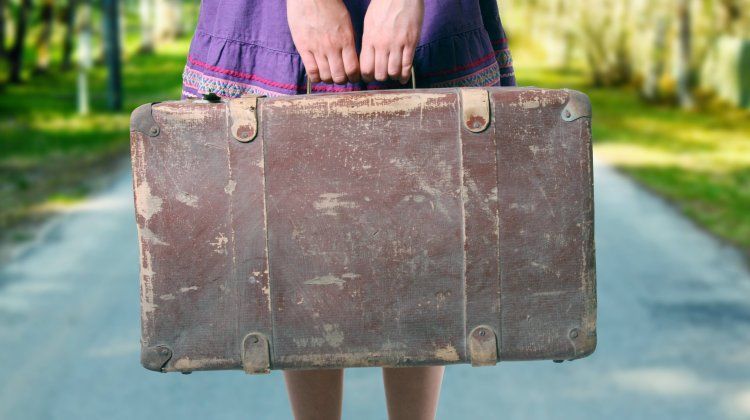 Girl with Luggage on the Road