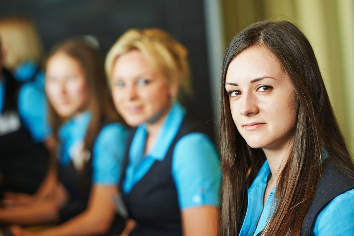 Female Receptionist Worker Standing At a Hotel Counter