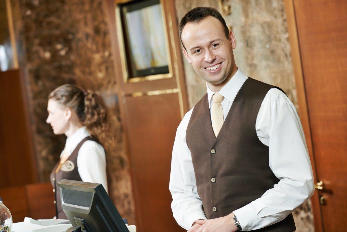Happy Receptionist Worker At Hotel Counter