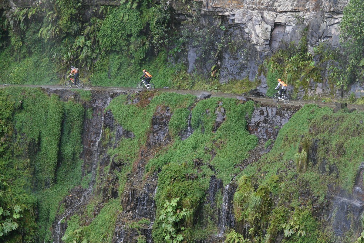 Mountain Bikers Riding Along the Narrow Road of Death On The North Yungas Road