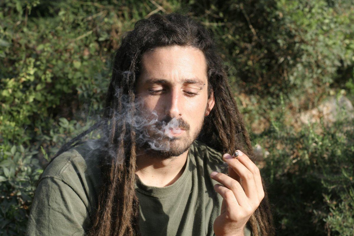 Hippy Preparing, Rolling And Smoking Marijuana Joint