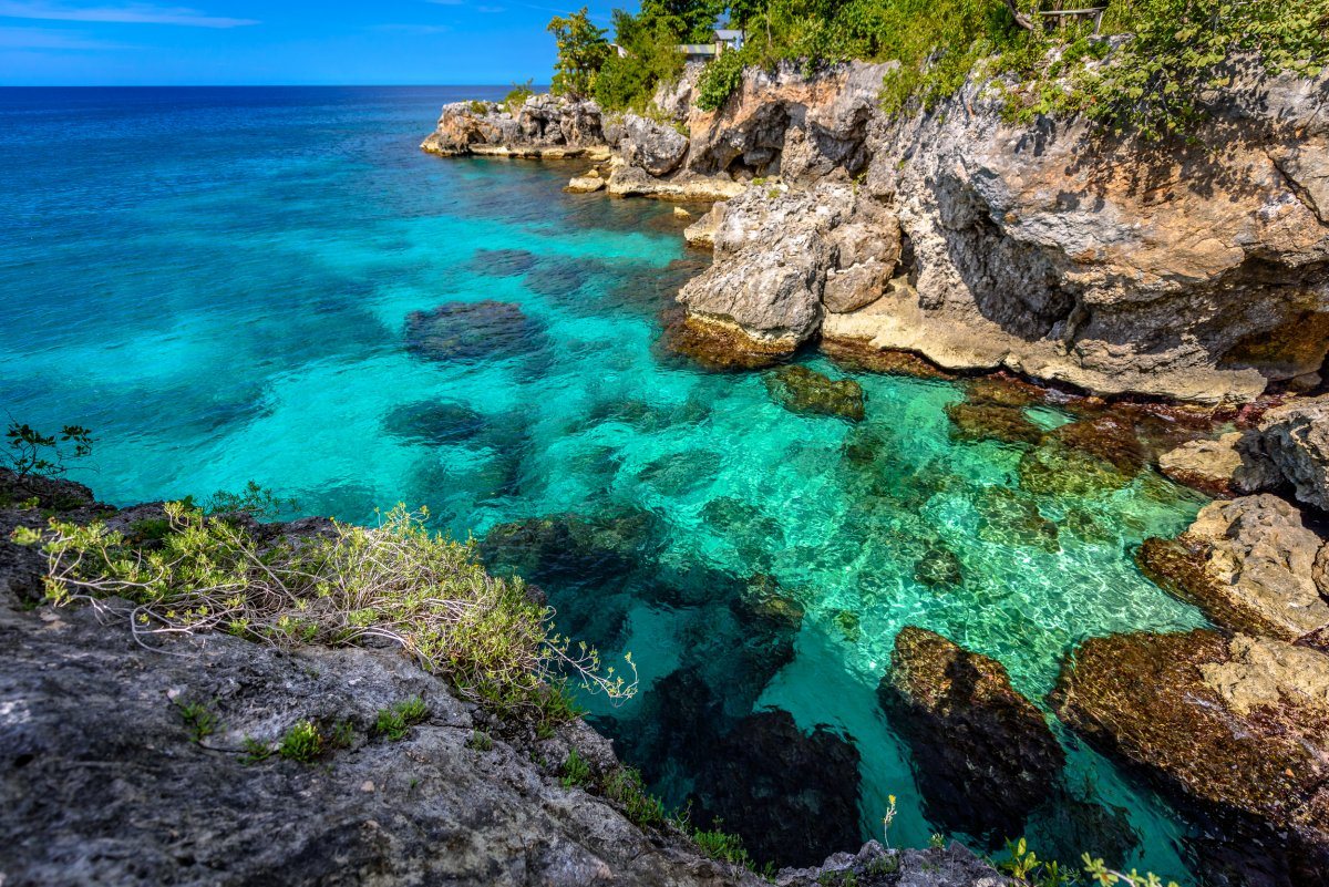 Beautiful clear turquoise water near rocks and cliffs in Negril Jamaica