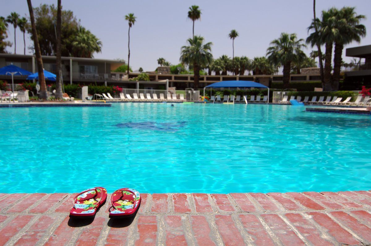 Sandals Next To Large Empty Swimming Pool In Palm Springs
