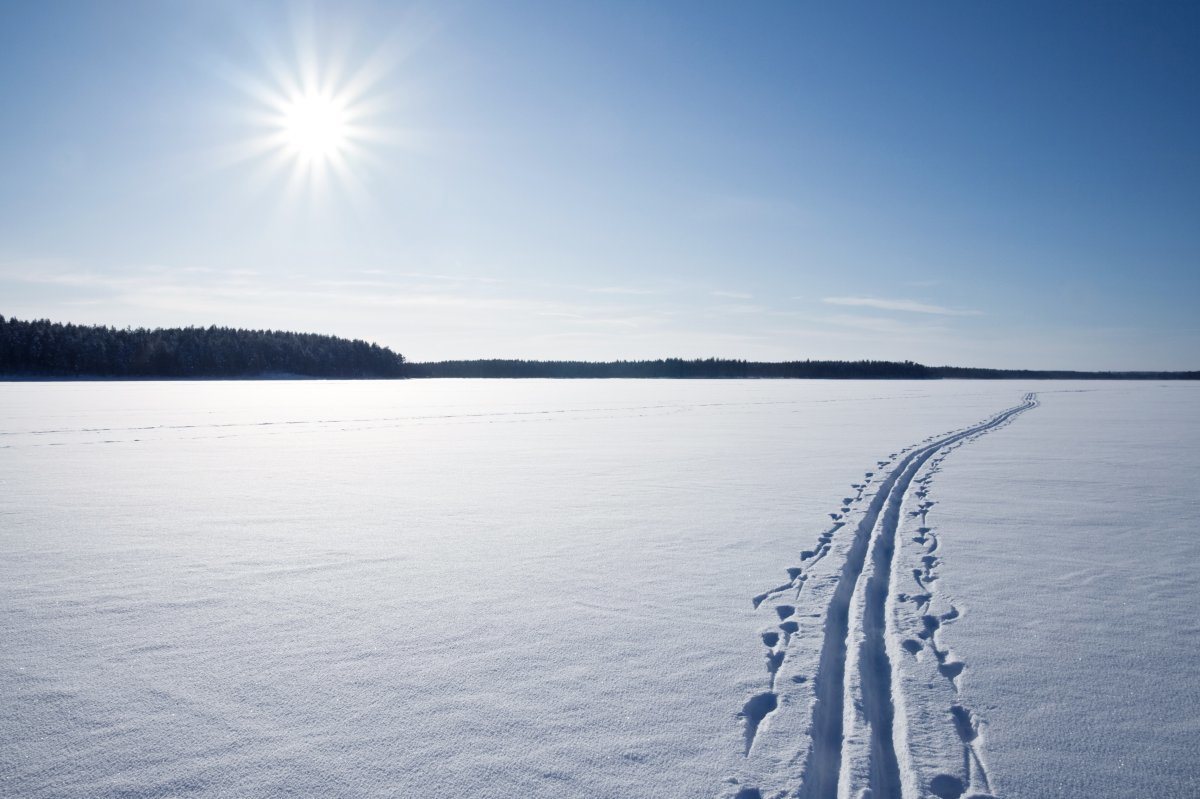 Sun, Snow And Ski Track Crossing A Frozen Lake