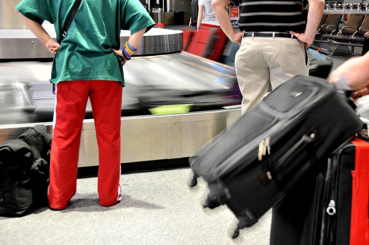 Passengers Wait For Baggage At Airport Carousel