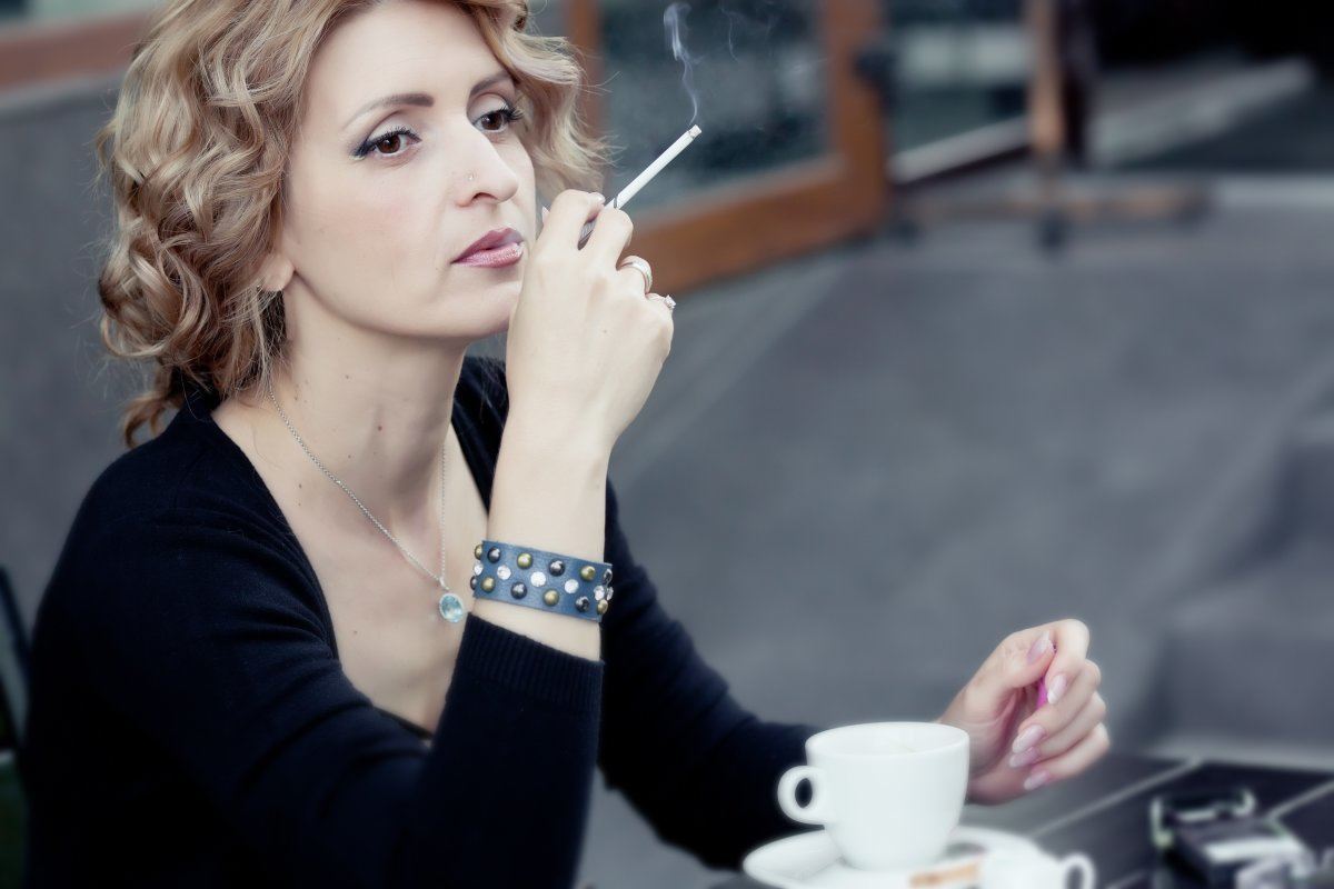 Woman With Cup Of Coffee In Summer Cafe
