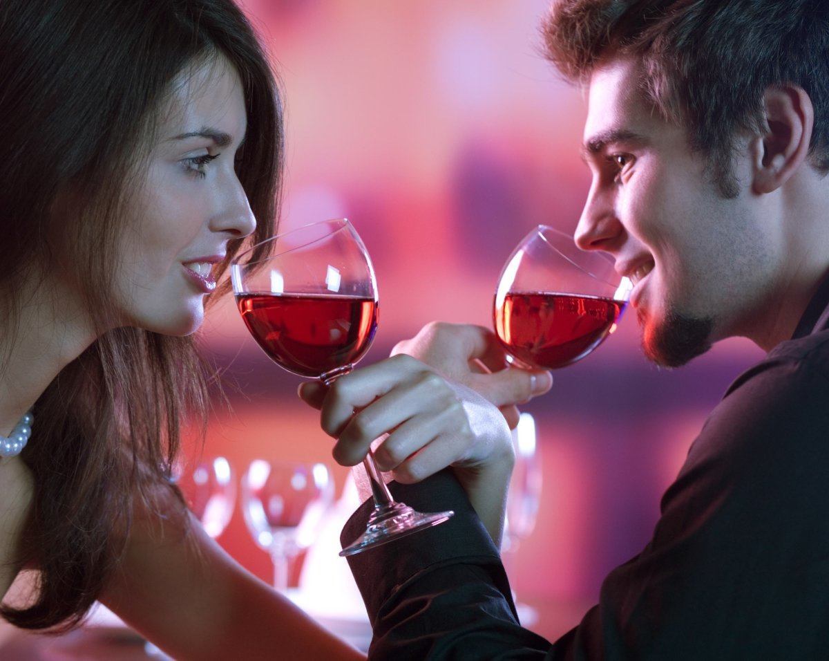 Young Happy Amorous Couple With Glasses Of Redwine On Romantic Date At Restaurant