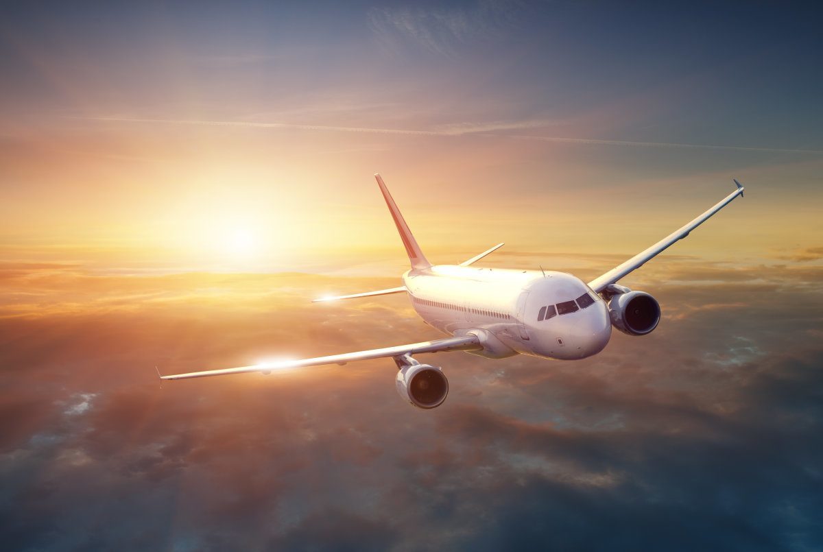 Airplane In The Sky At Sunset
