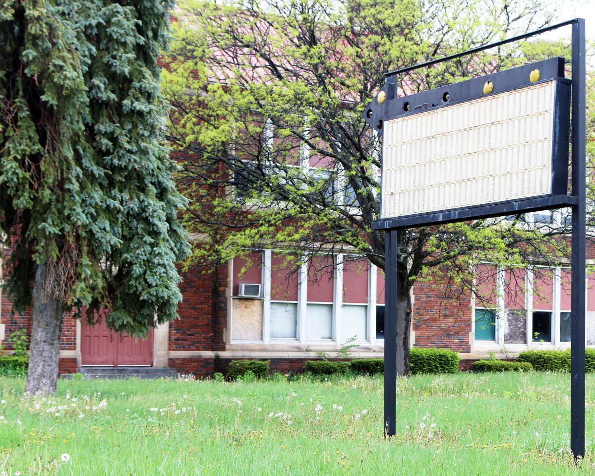 Blank Sign In Front Of An Abandoned Building.