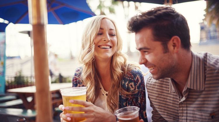 Happy Couple Having A Good Time Drinking Beer Together At Outdoor Pub