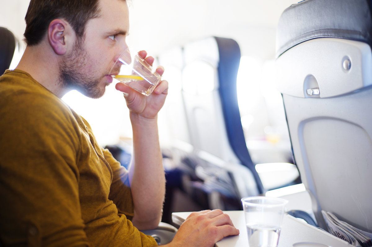 [man-drinking-water-on-a-plane]