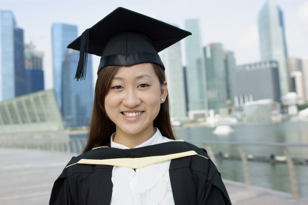Smiling Asian Graduate Lady With City Background