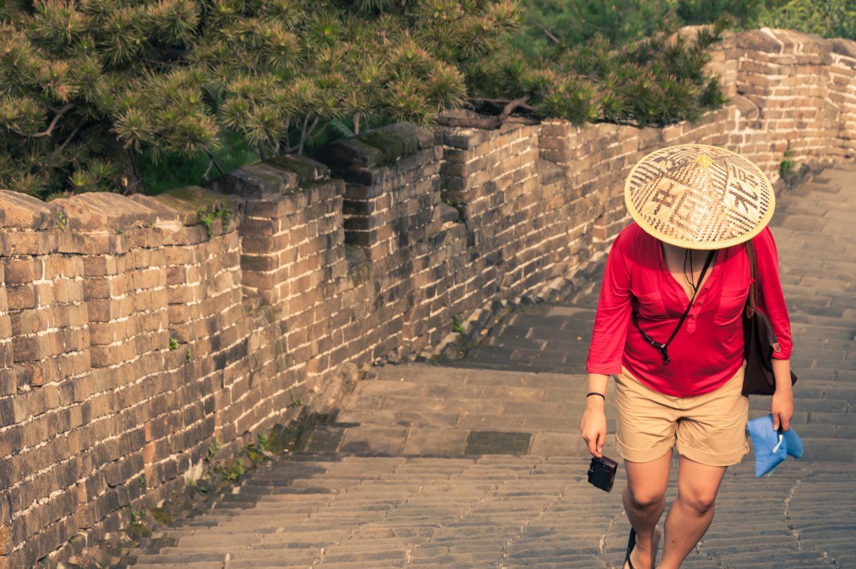 A Woman Climbs The Great Wall Of China.