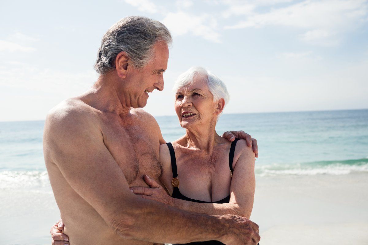 Happy Senior Couple Embracing On The Beach