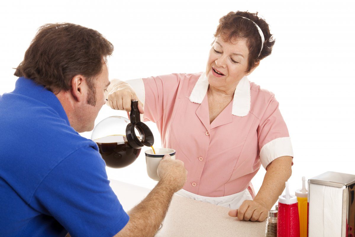 Waitress In A Diner Freshens Cup Of Coffee
