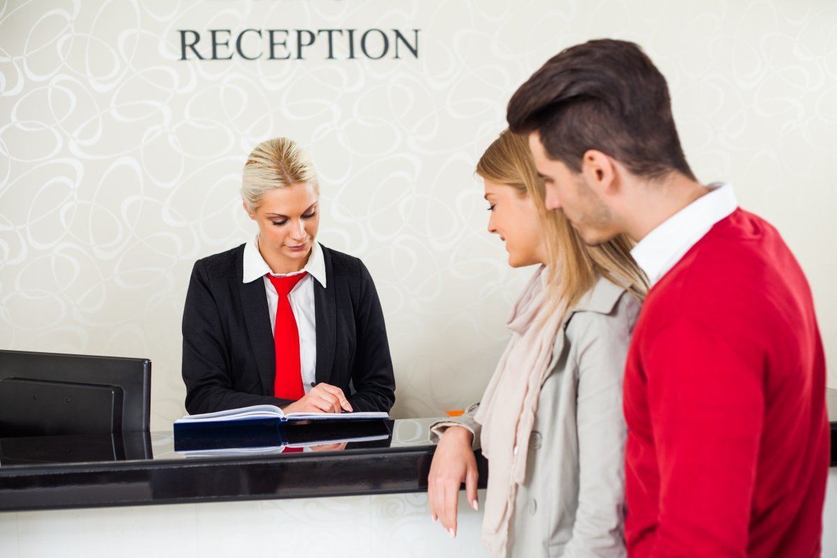 Young Couple Check In At Hotel Reception