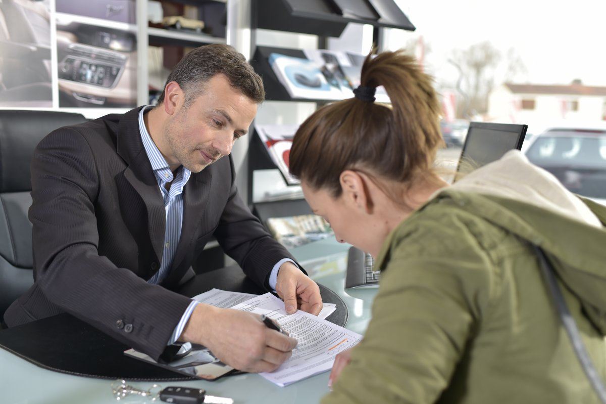 Young Woman Signing Car Rental Contract