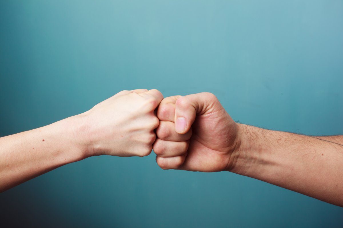 Young Man And Woman Are Fist Bumping