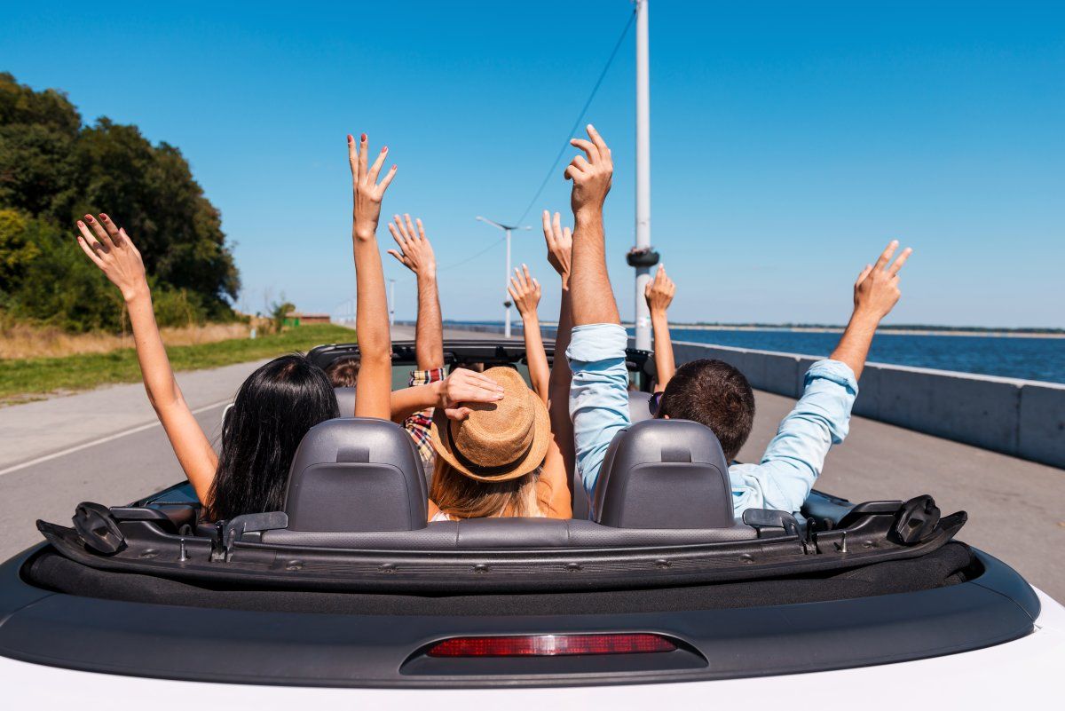 Young People Enjoy Road Trip In Car