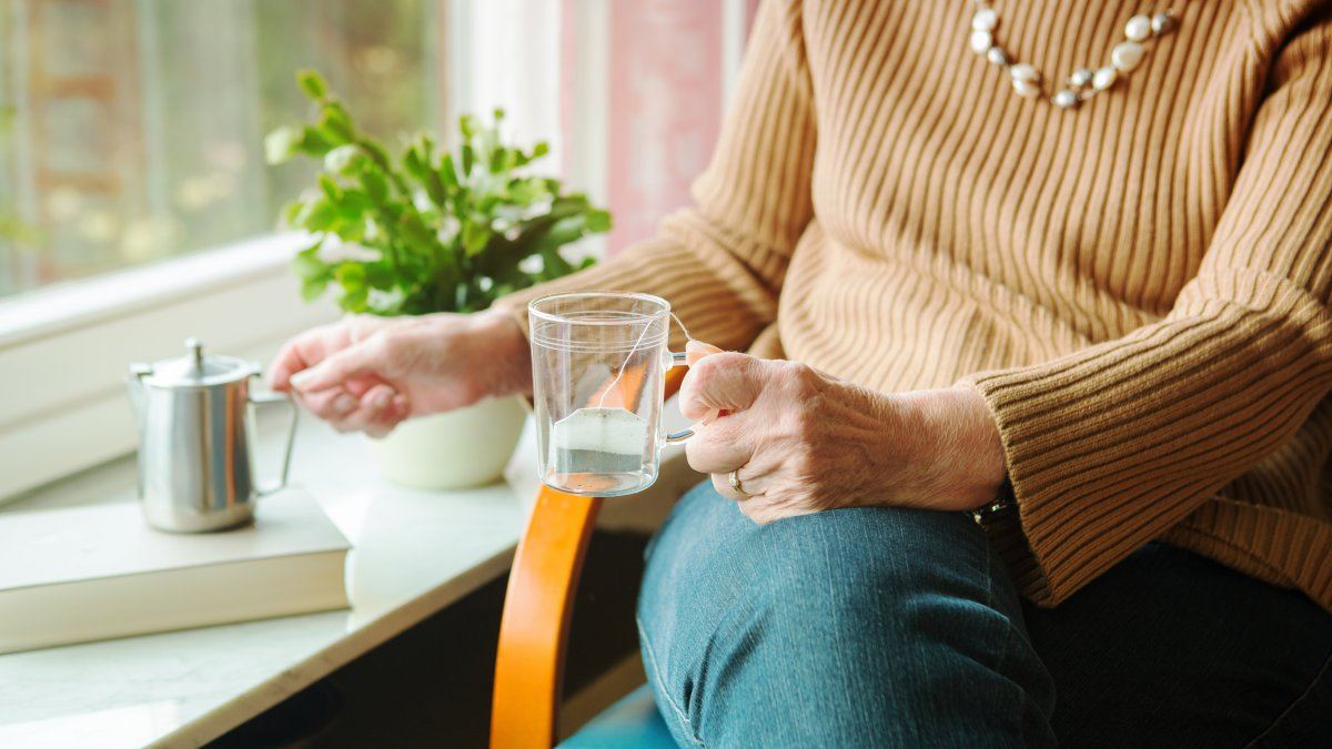 Closeup Older Woman Pouring Tea Glass