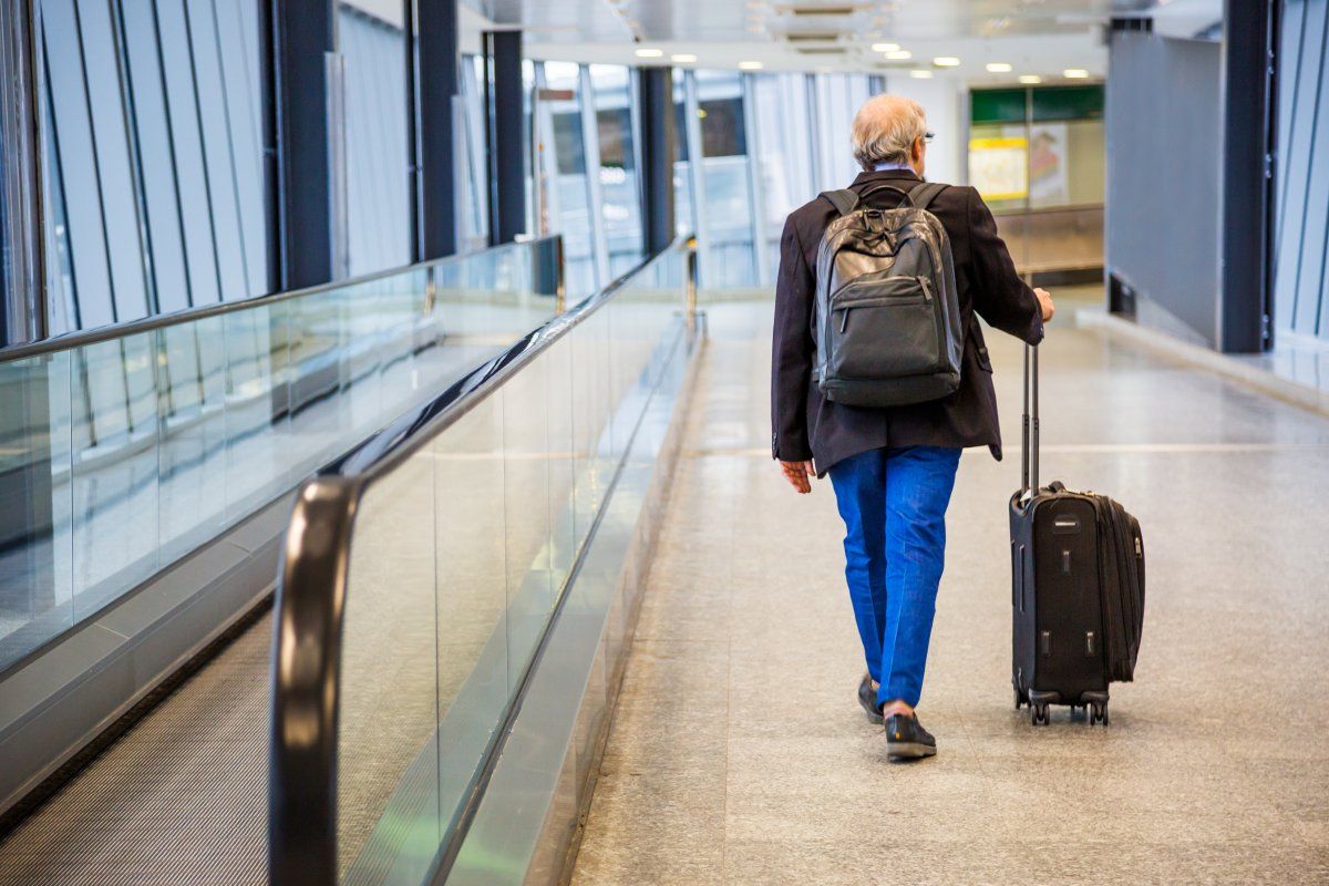 Senior Businessman Walking Trolley Airport On