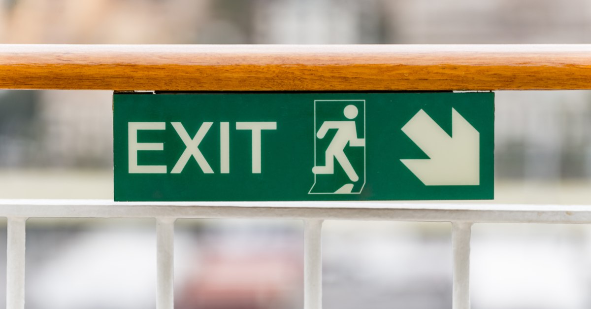 Attention green Exit sign with arrow on wooden railing cruise