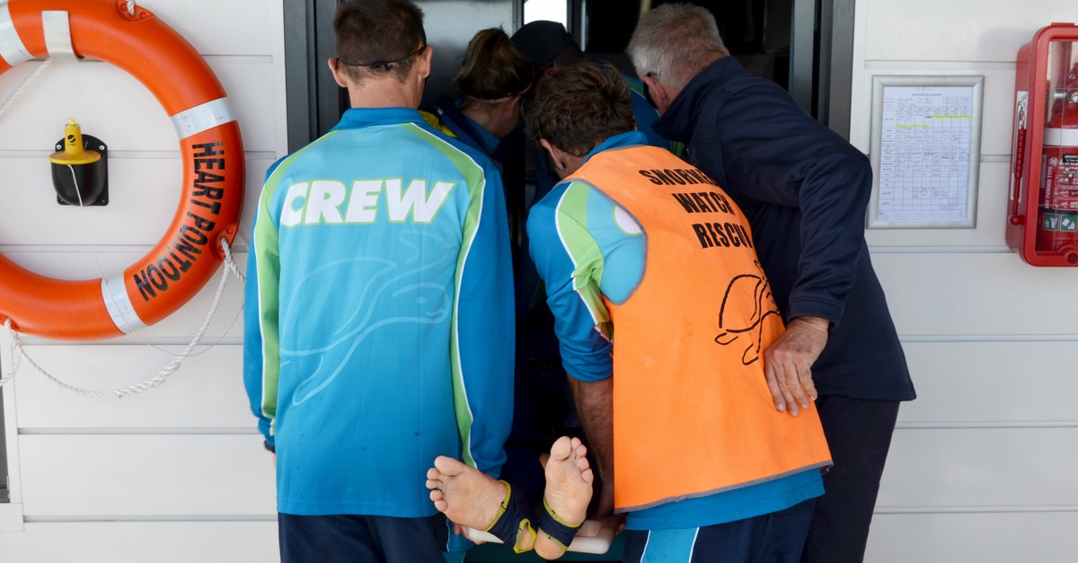 Cruise tour staff helping injured person in an emergency drill