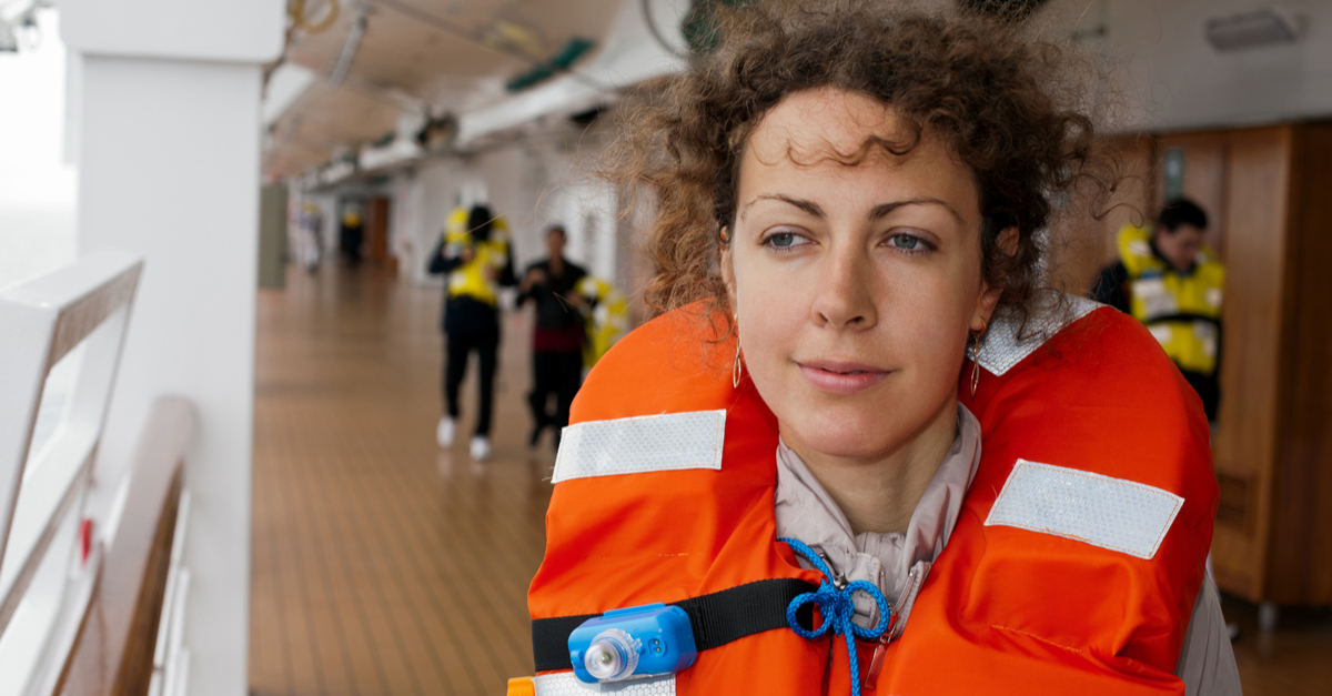 girl in life jacket on ship with other people