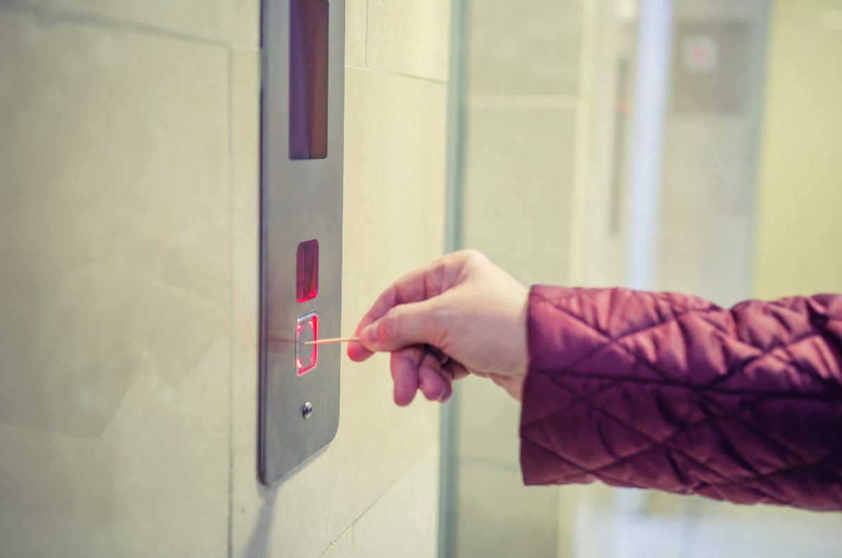 woman avoid touching a lift button